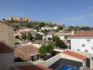 uitzicht op een stad met een kasteel op de achtergrond bij Apartamentos García de Paredes in Trujillo