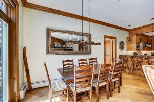 a dining room with a wooden table and chairs at Ski-in Ski-out 1 BdrDen in exclusive Horizon Pass condo in Avon