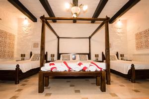 a bedroom with two beds and a table with towels at Il-Bejta Farmhouse in Għarb