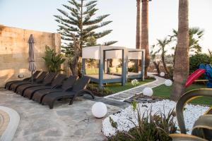 a playground with black chairs and a gazebo at Il-Bejta Farmhouse in Għarb