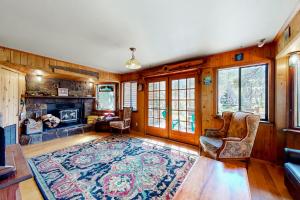 a living room with a fireplace and wooden walls at Sierra Secret in Soda Springs