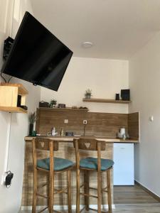 a kitchen with a wooden bar with stools at Aurora Apartment in Kikinda