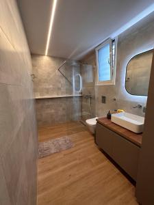 a bathroom with a sink and a toilet and a mirror at Elia Luxury Residence in Chalkida