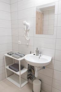 a white bathroom with a sink and a mirror at K111 Klapka Apartment in Budapest