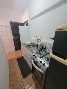 a kitchen with a stove and a sink at Pousada das Artes 2 in Mongaguá