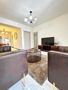 a living room with a couch and a table and a television at Lovely 2bedroom Apartment overlooking Nairobi City in Nairobi