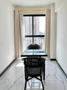 a glass table and a chair in a room with a window at Lovely 2bedroom Apartment overlooking Nairobi City in Nairobi