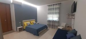 1 dormitorio con 1 cama azul y amarilla y TV en The Zigghy's Room, en Matera
