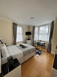 1 dormitorio con 1 cama grande y 1 mesa en WIllesden Lodge Guest House, en Londres