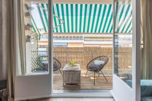 an open door to a balcony with chairs and a table at Lovely Apartment near Monaco in Roquebrune-Cap-Martin