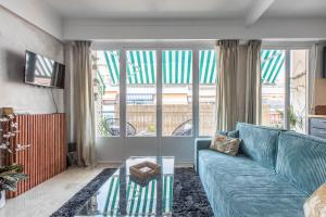 een woonkamer met een blauwe bank en een glazen tafel bij Lovely Apartment near Monaco in Roquebrune-Cap-Martin