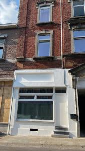 una puerta de garaje blanca en un edificio de ladrillo en Studio chic proche aéroport & centre-ville en Charleroi