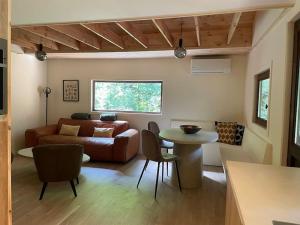 a living room with a couch and a table at Prachtige chalet in het bos met sauna! in Lanaken