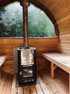 um fogão ao ar livre numa cabina com uma janela em Prachtige chalet in het bos met sauna! em Lanaken