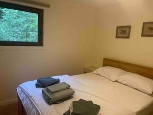 a bedroom with a bed with two bags on it at Prachtige chalet in het bos met sauna! in Lanaken