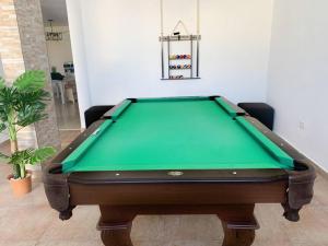 a pool table in a living room with a green at Villa del Sol in Luquillo
