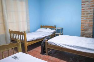 a room with two beds and a blue wall at VILLA LAS FLORES in La Libertad