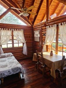 a bedroom with a bed and a table in a cabin at Cabañas La Ponderosa in Villa Ventana