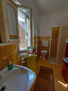 een badkamer met een bad, een toilet en een raam bij Casa nel centro storico a Loreto, 2 km dal mare in Loreto