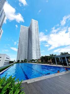 een groot zwembad voor twee hoge gebouwen bij Grass Residences T4 383 in Manilla