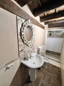 uma casa de banho com um lavatório, um espelho e um WC. em Little House 51, Palermo em Palermo