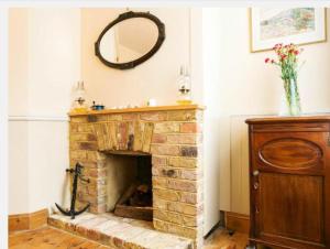 a living room with a brick fireplace with a mirror at Fishermen Cottage - 5 star location- 90sq garden -2 living room- 2 bath room -pets friendly -comfortably sleep 5-6 people -50 percent off monthly -self check in in Deal