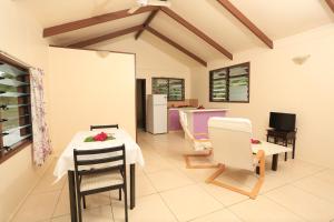 a kitchen and dining room with a table and chairs at Ranginui Sunset in Arutanga