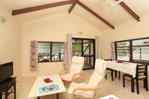 a living room with a table and chairs and a television at Ranginui Sunset in Arutanga