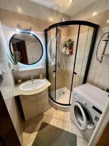 a small bathroom with a shower and a washing machine at Apartmán Tatranská Kotlina in Vysoke Tatry - Tatranska Kotlina