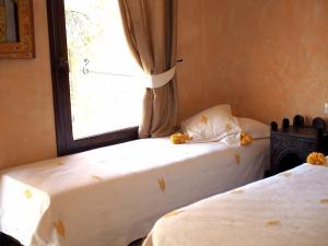 two beds in a room with a window at Paradis Nomade in Azrarag