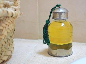 a bottle of oil sitting on a counter next to a basket at Paradis Nomade in Azrarag