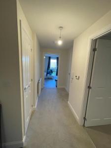 an empty hallway with a hallway leading to a room at Luxurious Apartment in Brooklands in Milton Keynes