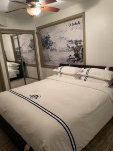 a bedroom with a large white bed with a ceiling fan at Wangshi China Palace in Oklahoma City