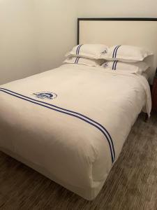 a bed with white sheets and blue stripes on it at Wangshi China Palace in Oklahoma City