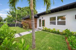a house with a palm tree in front of it at Mango Lovers Zen Beach Retreat w Hot Tub in Fort Lauderdale
