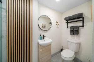 a bathroom with a toilet and a sink and a mirror at Mango Lovers Zen Beach Retreat w Hot Tub in Fort Lauderdale +14 photos