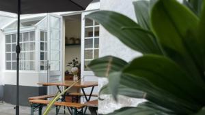 un patio con mesa y sombrilla en A Vista dos Verdes en Furnas