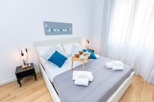 - une chambre avec un lit doté d'oreillers bleus et d'une table dans l'établissement Noh collection 3BDR apartment- Trastevere Area, à Rome