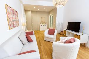un salon avec des meubles blancs et une télévision à écran plat dans l'établissement Noh collection 3BDR apartment- Trastevere Area, à Rome