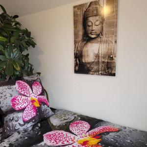a picture of a buddha on a wall with flowers at Appartement im Schwarzwaldhaus in Hüfingen