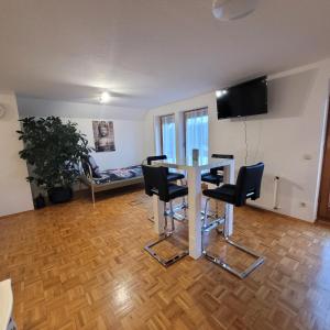 a room with a table with chairs and a flat screen tv at Appartement im Schwarzwaldhaus in Hüfingen