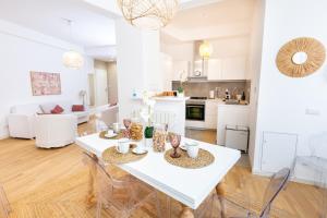 une cuisine et un salon avec une table et des chaises blanches dans l'établissement Noh collection 3BDR apartment- Trastevere Area, à Rome 29 autres photos