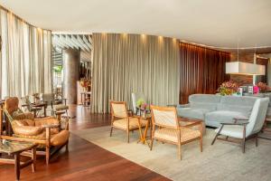 a living room with a blue couch and chairs at Hotel Fasano Rio de Janeiro in Rio de Janeiro