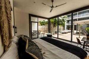 sypialnia z dużym łóżkiem i dużym oknem w obiekcie Beautifully Designed 3-BR Escape Close to Downtown w mieście Tulum