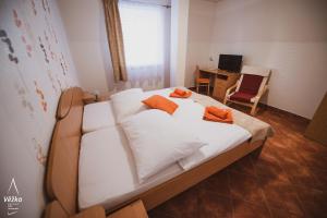 a bedroom with a bed with orange pillows on it at Pension Věžka in Šternberk