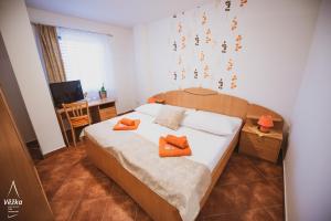 a bedroom with a bed with two orange pillows on it at Pension Věžka in Šternberk