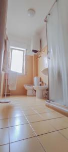 La salle de bains est pourvue de 2 toilettes et d'une fenêtre. dans l'établissement Blue Wave Holiday House, à Aci Castello