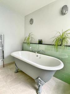 uma banheira branca numa casa de banho com plantas em Stunning 2 bedroom Sea View - Margate Old Town em Margate