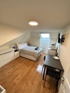 a bedroom with a bed and a desk in it at WIllesden Lodge Guest House in London