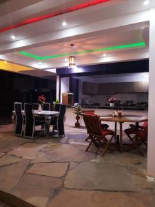 un comedor con mesas, sillas y luces en Donita's Seaview Apartments, en Mombasa